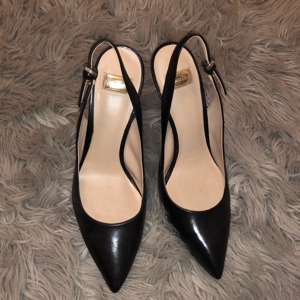 Lightly worn black pumps with gold detail in heel
